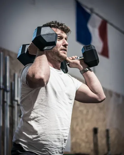 Un homme soulevant une haltère dans un exercice pour biceps