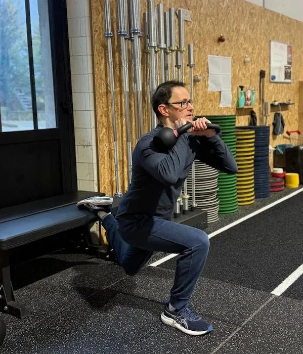 Geoffrey L., membre de CrossFit Mazamet, en train de faire une Bulgarian split squat avec des haltères.