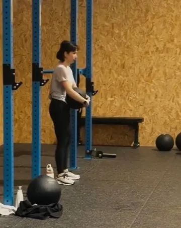 Janice D., membre de CrossFit Mazamet, en train de faire un squat avec une medicine ball.