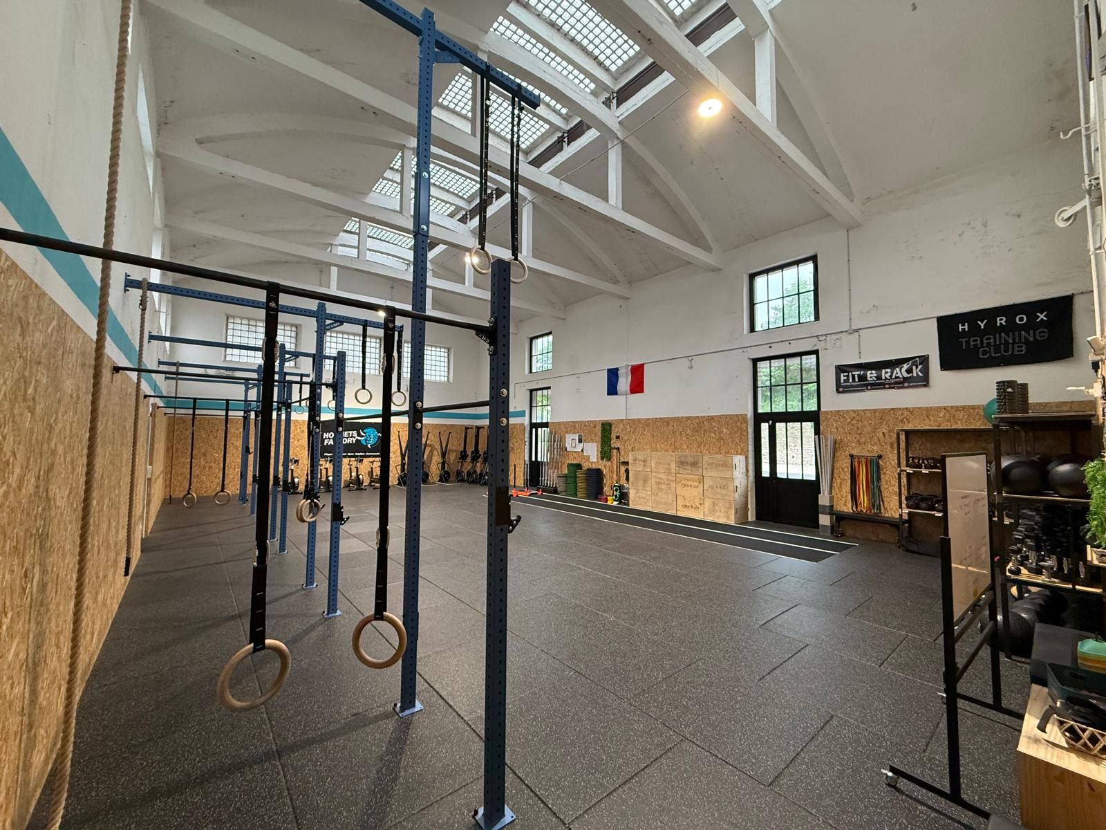 Grand angle de la salle Hornets Factory avec ses box, sa piste de course et ses rameurs.