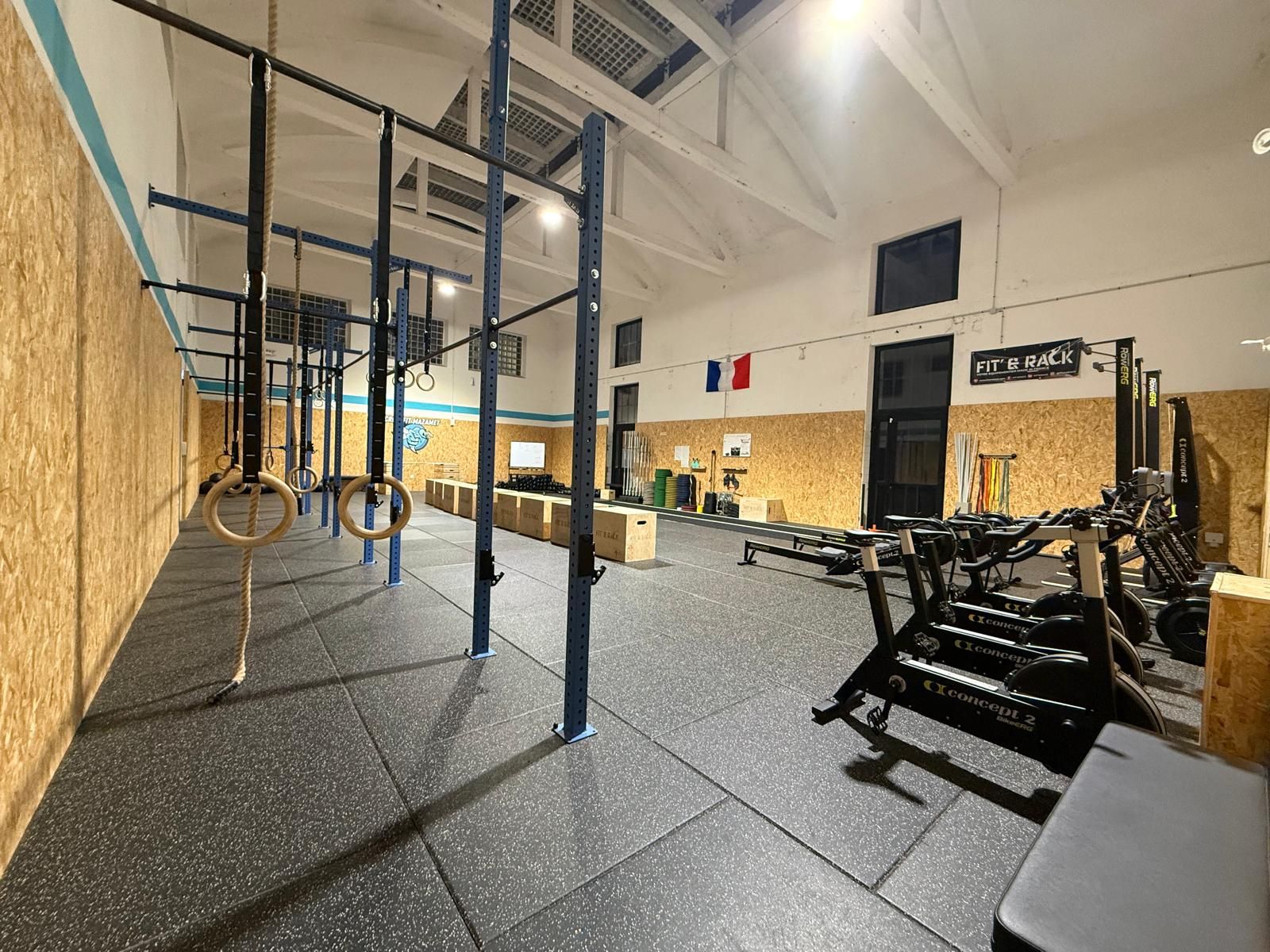 Grand angle de la salle Hornets Factory avec ses box, sa piste de course et ses rameurs.